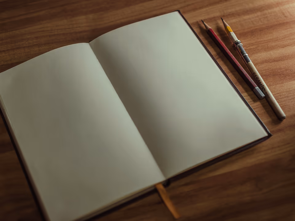 Blank sketchbook and pencil on a warm wooden table