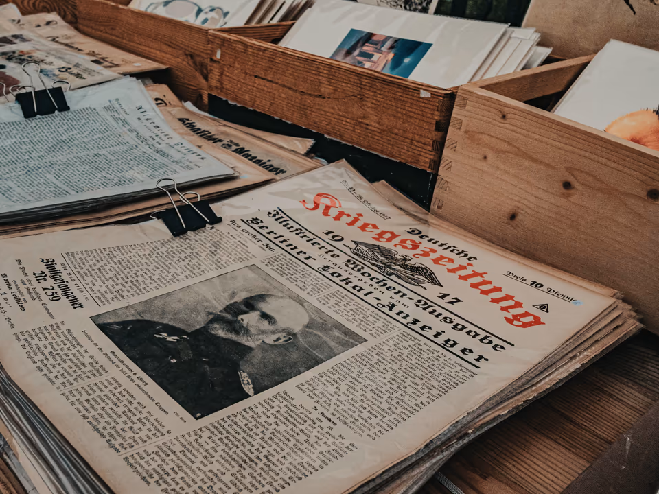 Crates of vintage newspapers stacked on warm wood